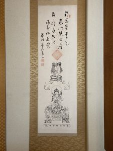 安間稲荷掛軸。鎮守祭神は稲穂を担ぎ白狐を従える白髪の老翁、奥の院・稲荷大明神である。前立本尊の十一面観音は通常脇侍に不動明王と毘沙門尊天を置くようだが、毘沙門尊天の代わりに大黒尊天が座している当山の三尊は特殊な例と思われる。